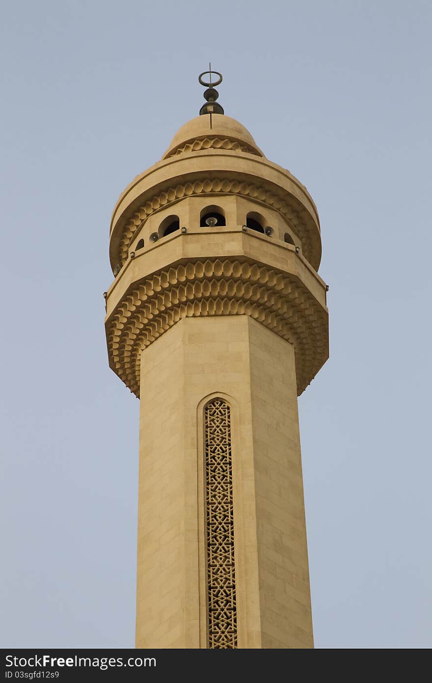 Isolated view of a single minaret against a blue sky