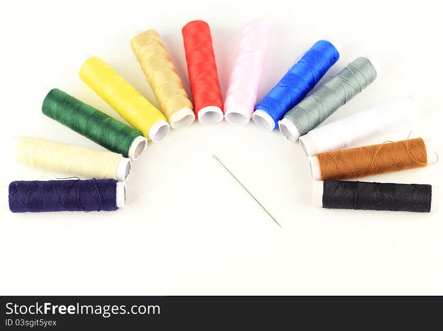 The color threads and needle  by semicircle pattern with isolated white background. The color threads and needle  by semicircle pattern with isolated white background