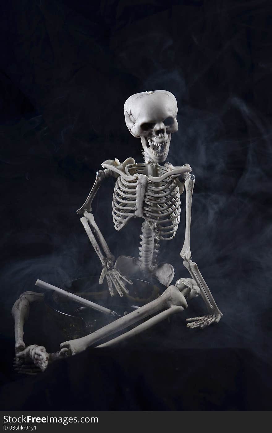 Skeleton holding an ashtray