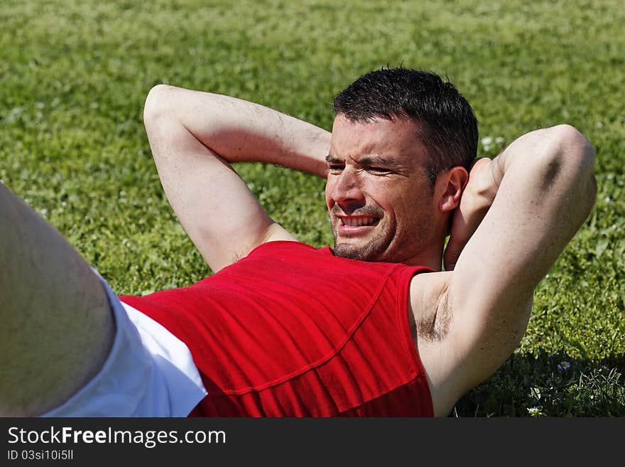 Man make abs exercise in a park. Man make abs exercise in a park