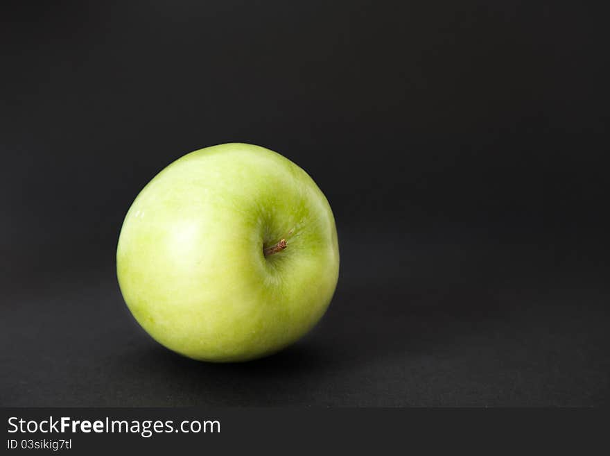 Green apple on black background