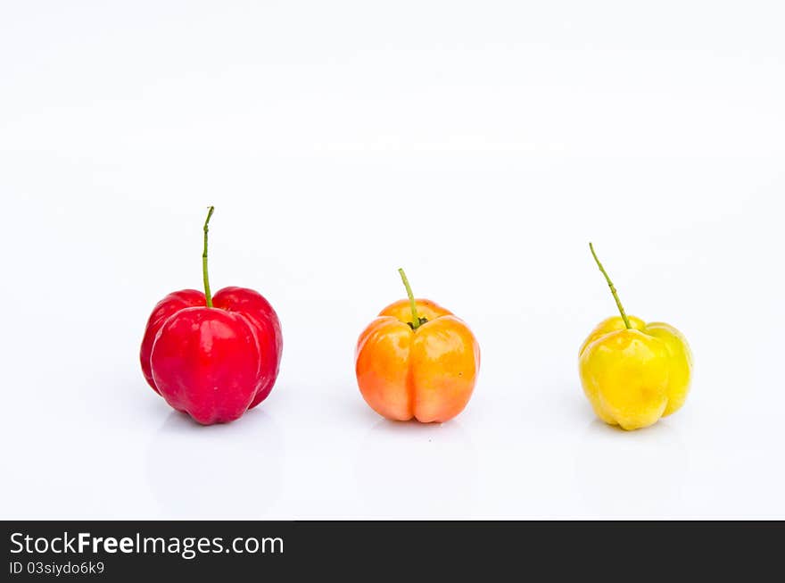 Row of three color cherry fruits on white background