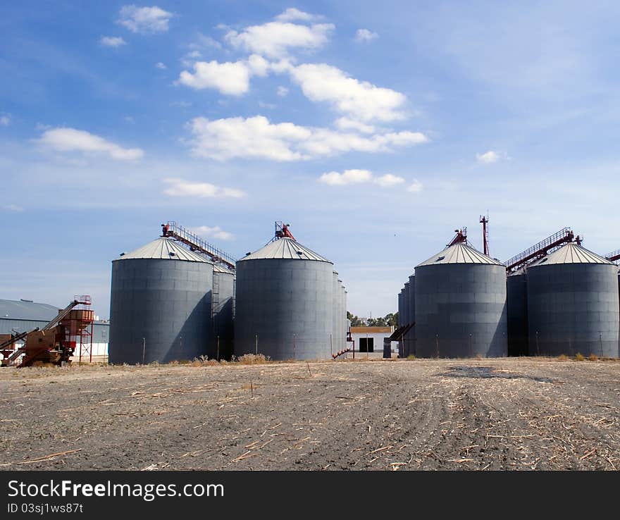 Several industrial deposits placed alongside each other in a rural landscape