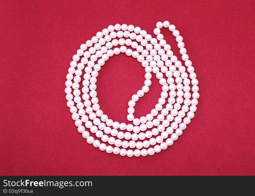 Light pink pear chains on display on red background. Light pink pear chains on display on red background