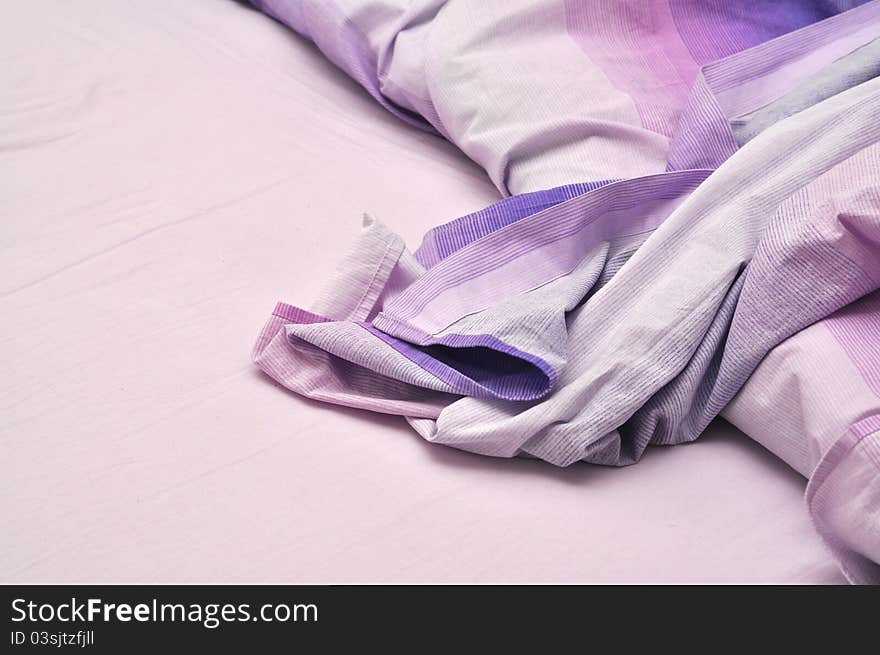 Messy bedclothes in violet color