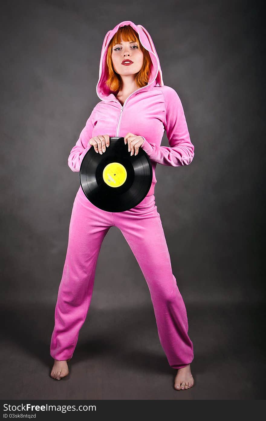 Cute young pretty girl in stylish pink wear with gramophone record. Cute young pretty girl in stylish pink wear with gramophone record