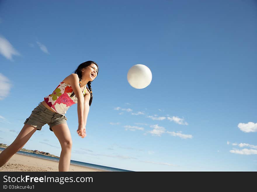 Teenage girl playing beach volleyball smiling