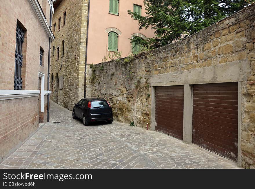 Garage on narrow street and black car