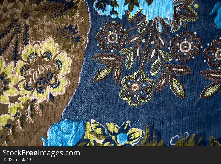 Colorful floral textile on blue fabric. Colorful floral textile on blue fabric