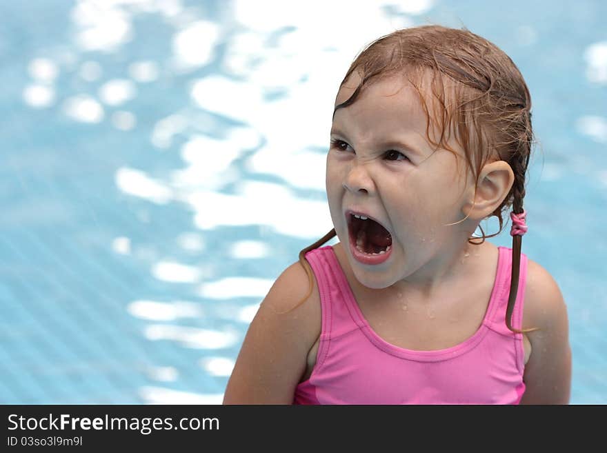 Little girl in the pool opened her mouth wide