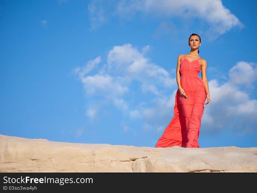 Beauty woman in red dress on the desert