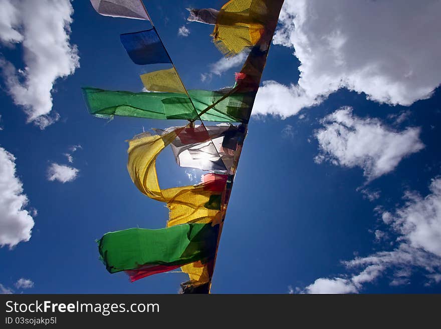 Praying flags floating in the wind on blue sky