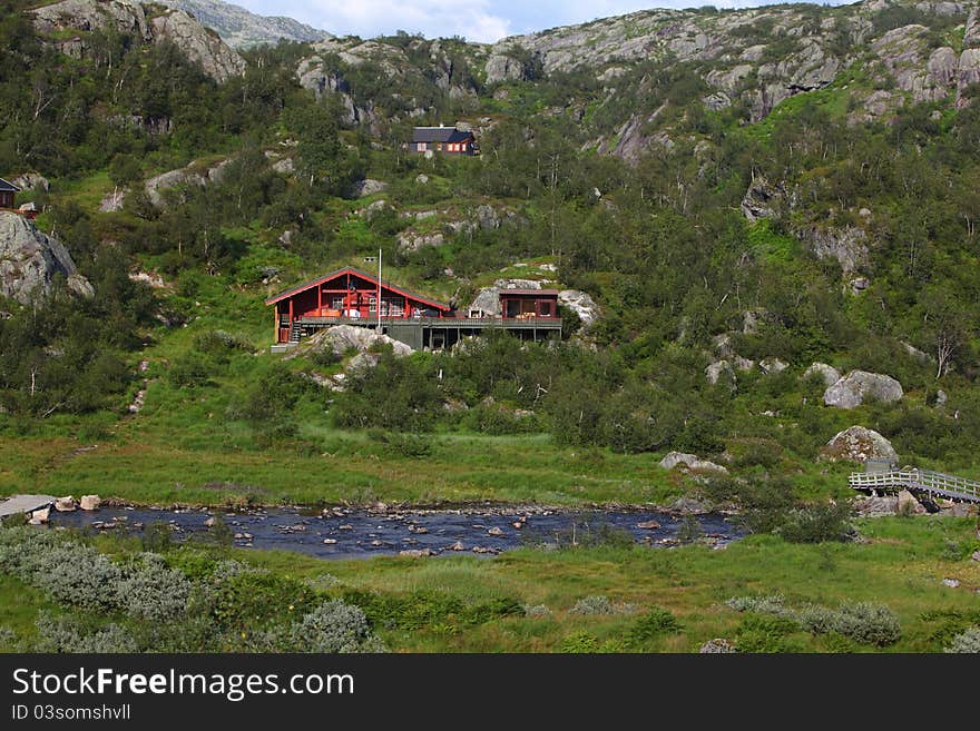 Wooden House Beside The River In The Mountains