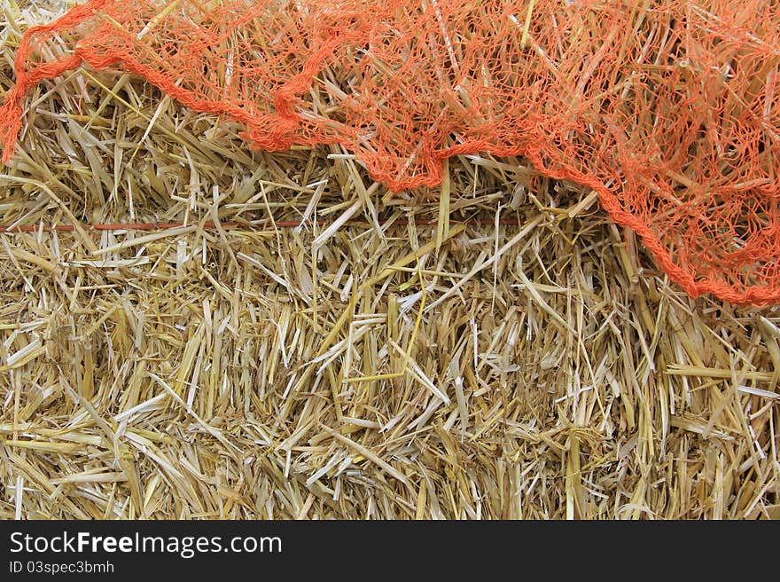 Bale of hay with orange netting fabric for Halloween. Bale of hay with orange netting fabric for Halloween.