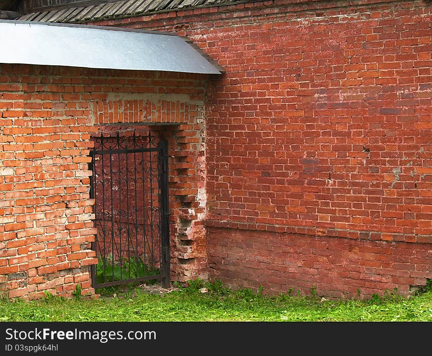 Openwork gate in the brick wall. Great Novgorod. Russia.