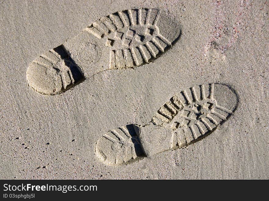 Boot footprints on the sand of a beach. Boot footprints on the sand of a beach