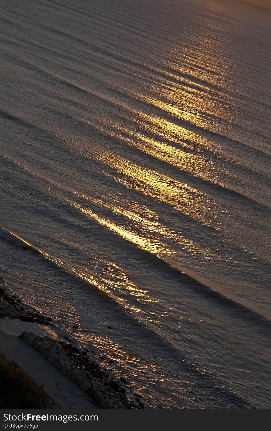 Picture of sea surface with waves located diagonally highlighted the rays of the rising sun. Picture of sea surface with waves located diagonally highlighted the rays of the rising sun.