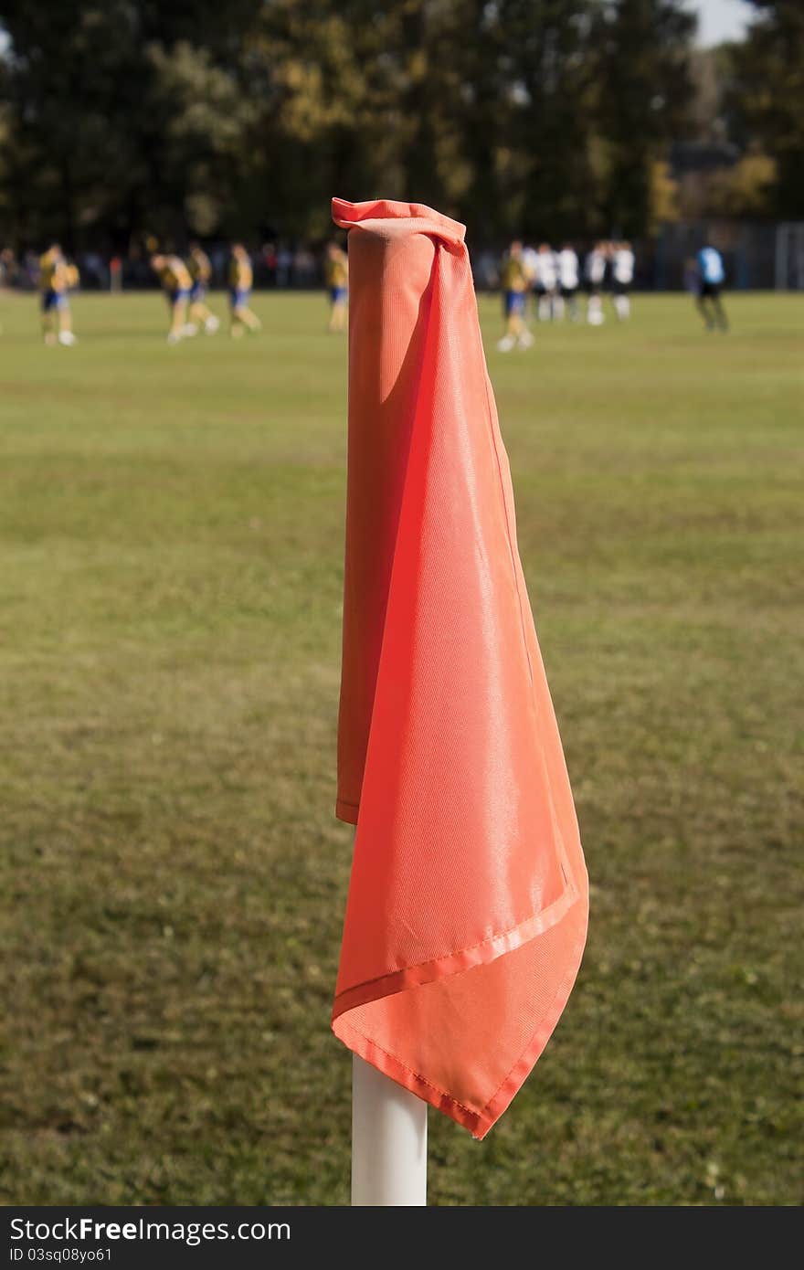 Orange corner flag close-up on the background of a football field