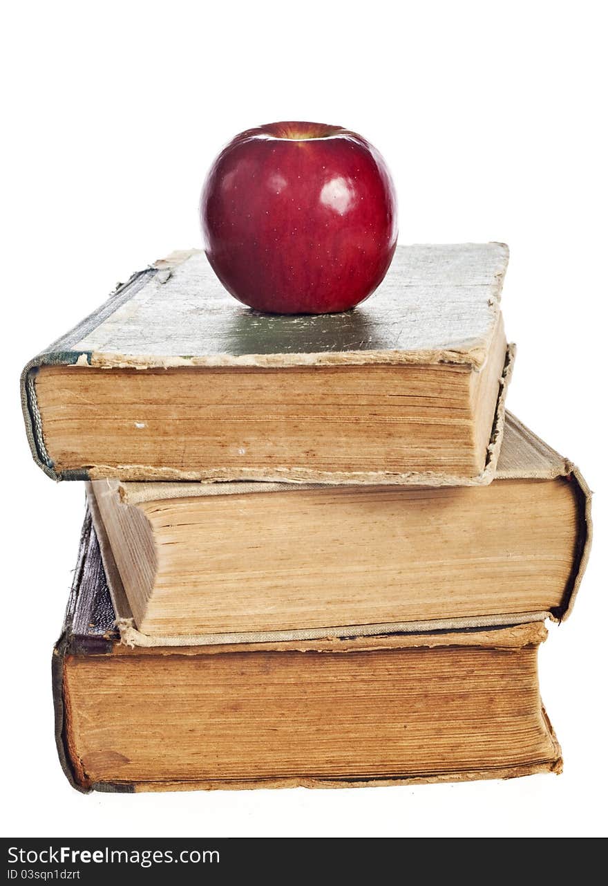 Stack of books with an apple on a white background