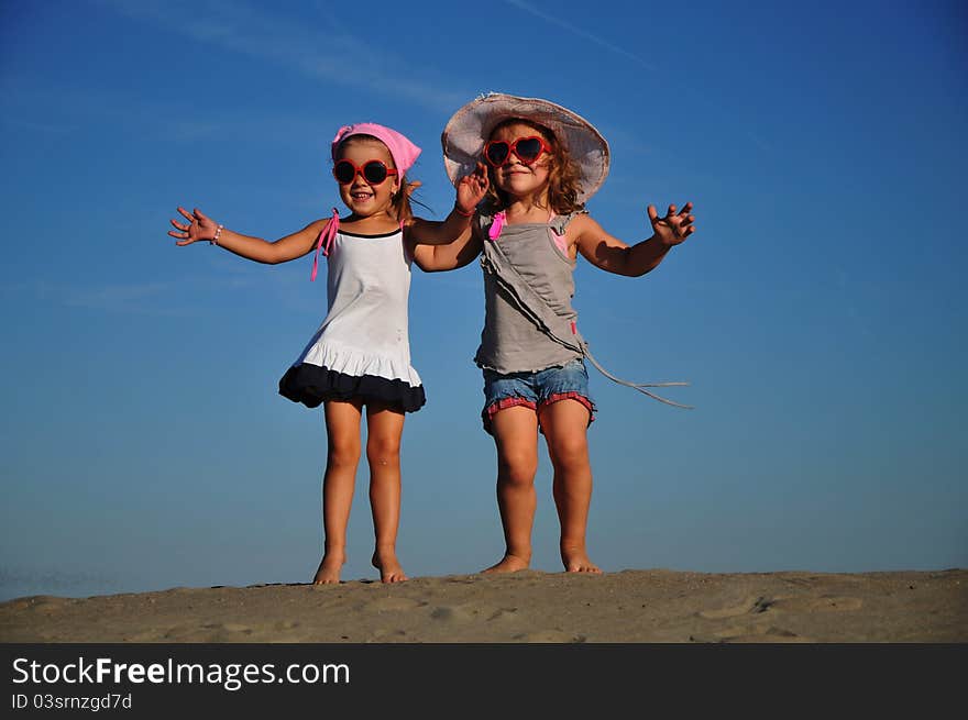 Girls jumping on the sandy beach