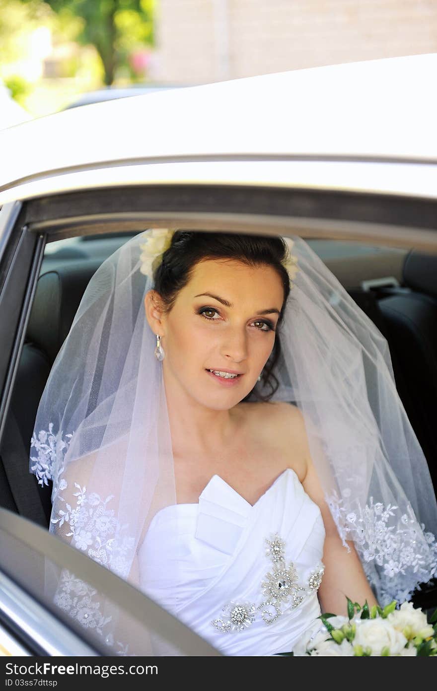 Bride with flowers in white car. Bride with flowers in white car