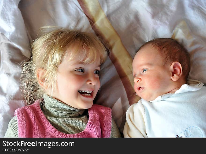 Girl with little brother  on parents  bed. Girl with little brother  on parents  bed