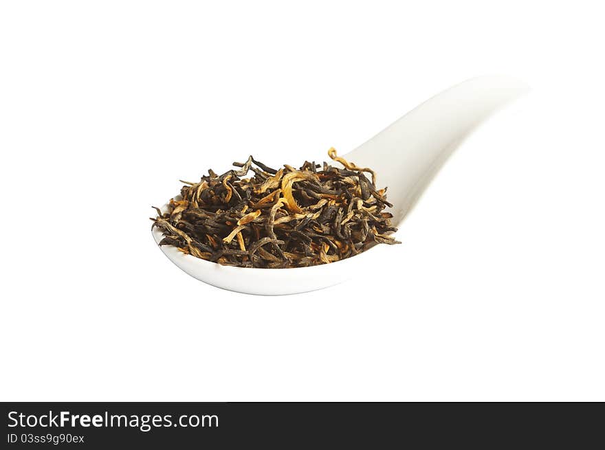 Black loose dried tea leaves in spoon, isolated