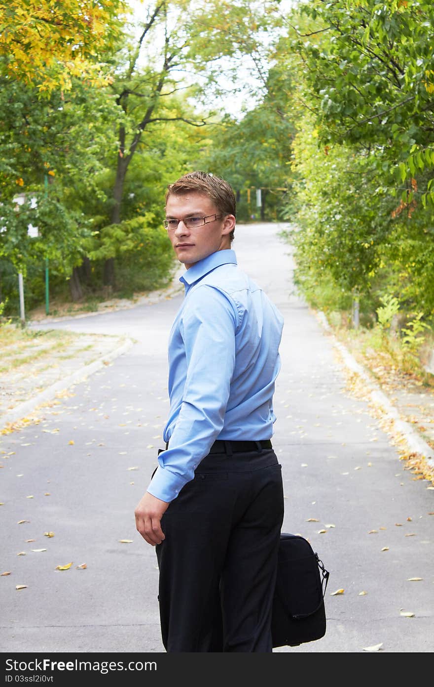 Businessman with computer in a park in autumn