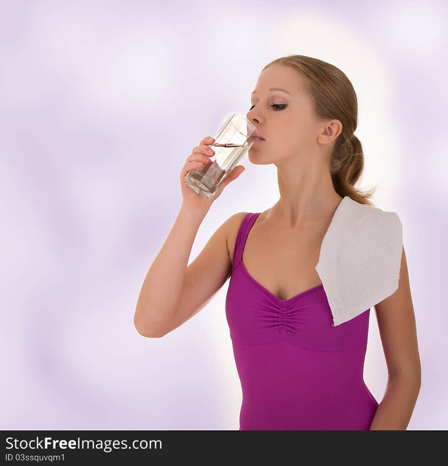 Beautiful athletic girl drinks water after a workout. Beautiful athletic girl drinks water after a workout