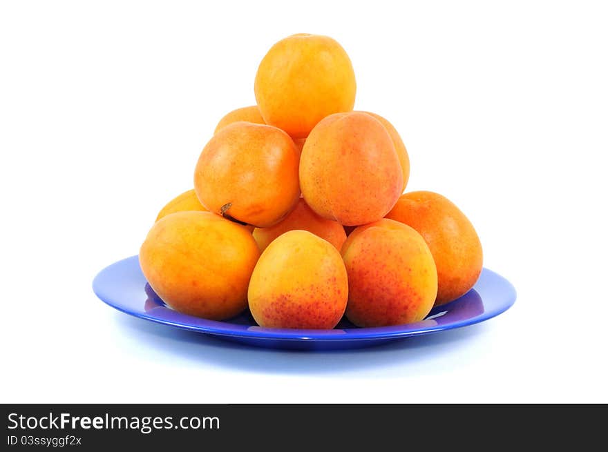 Fresh apricots on a blue plate, white background