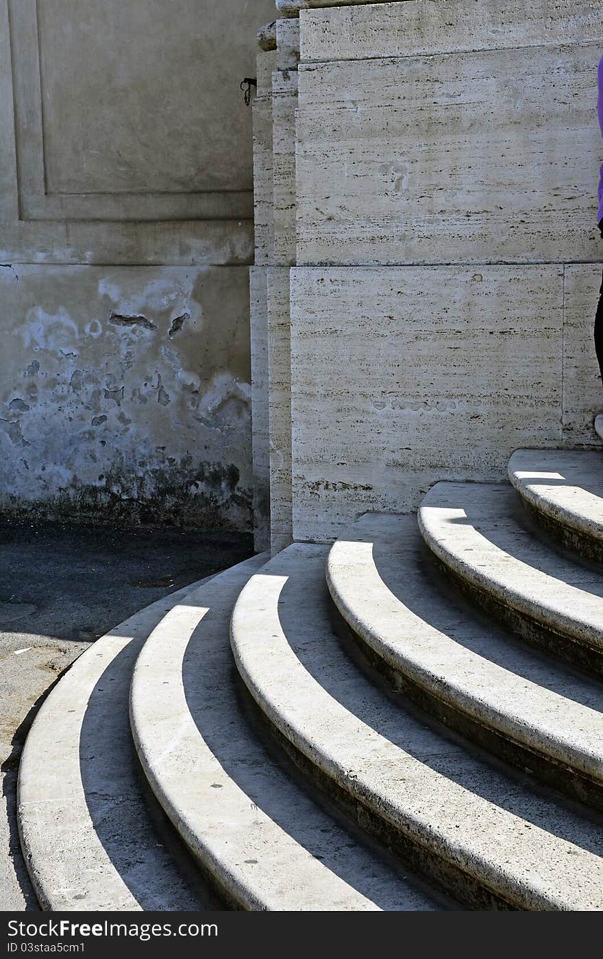 Round stairs in front of a marble building