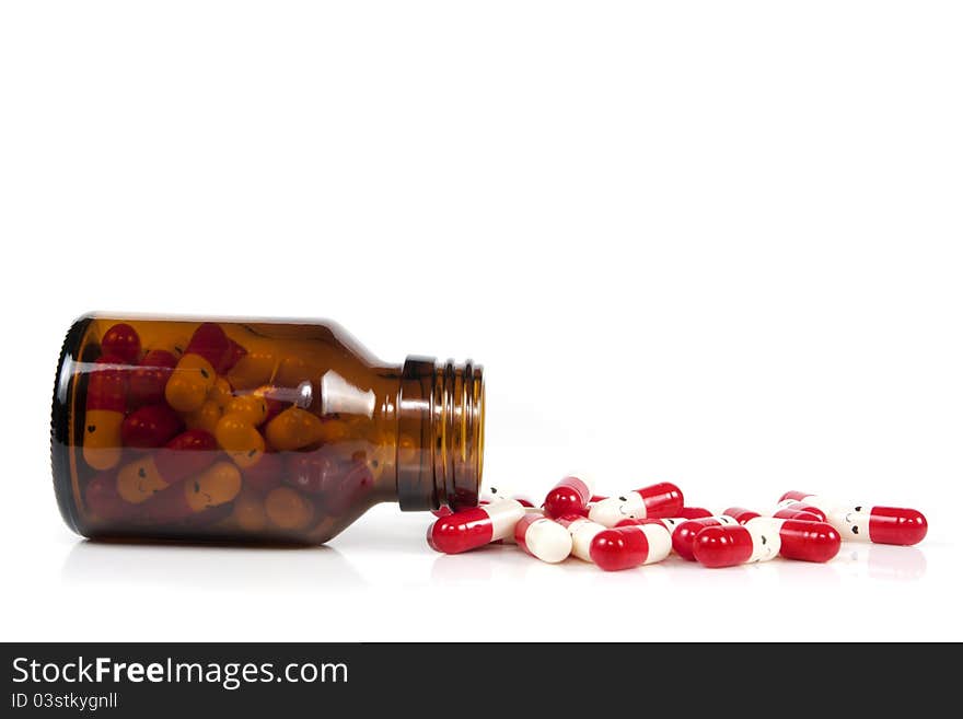 Open happy pill bottle with medicine spilling out of it on white