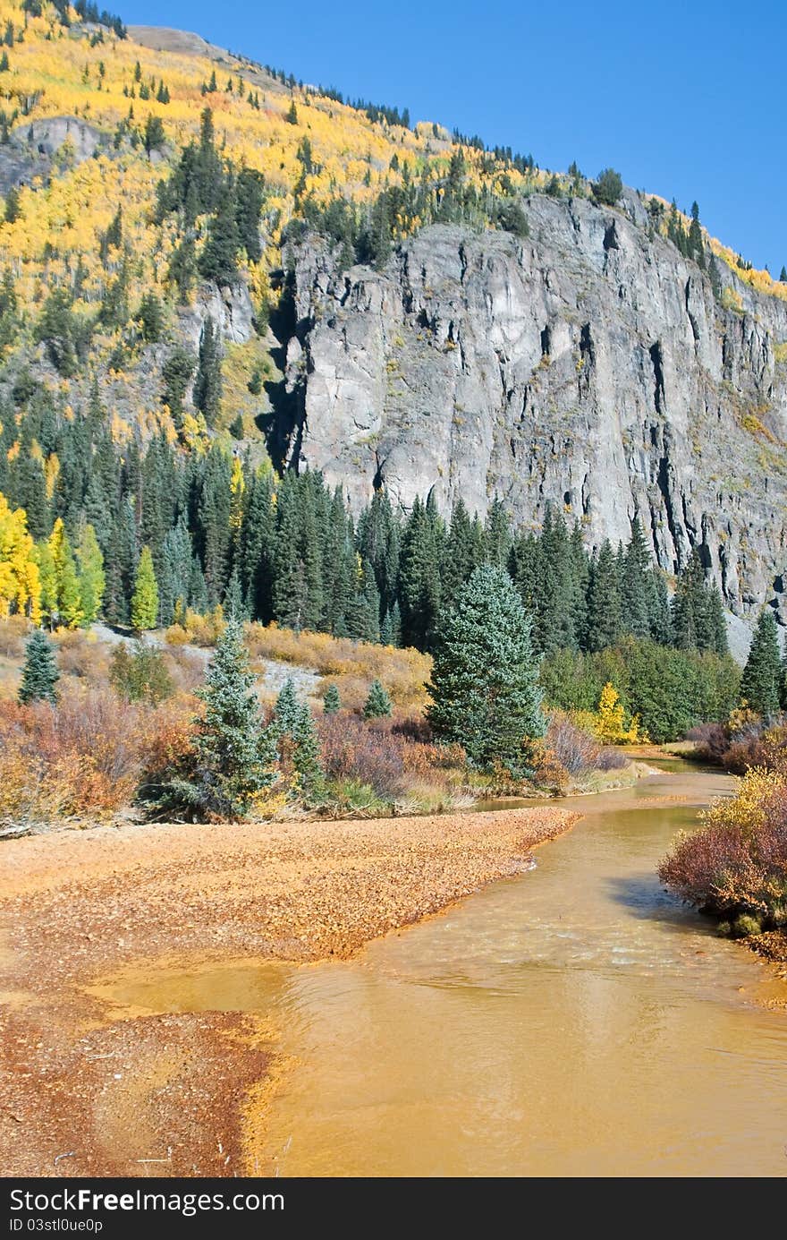 River runs yellow in the high country of Colorado in Fall. River runs yellow in the high country of Colorado in Fall