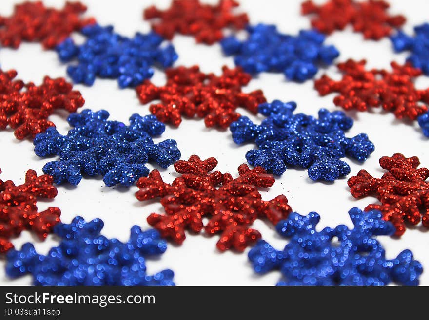 Red and blue plastic snowflakes on white. Red and blue plastic snowflakes on white