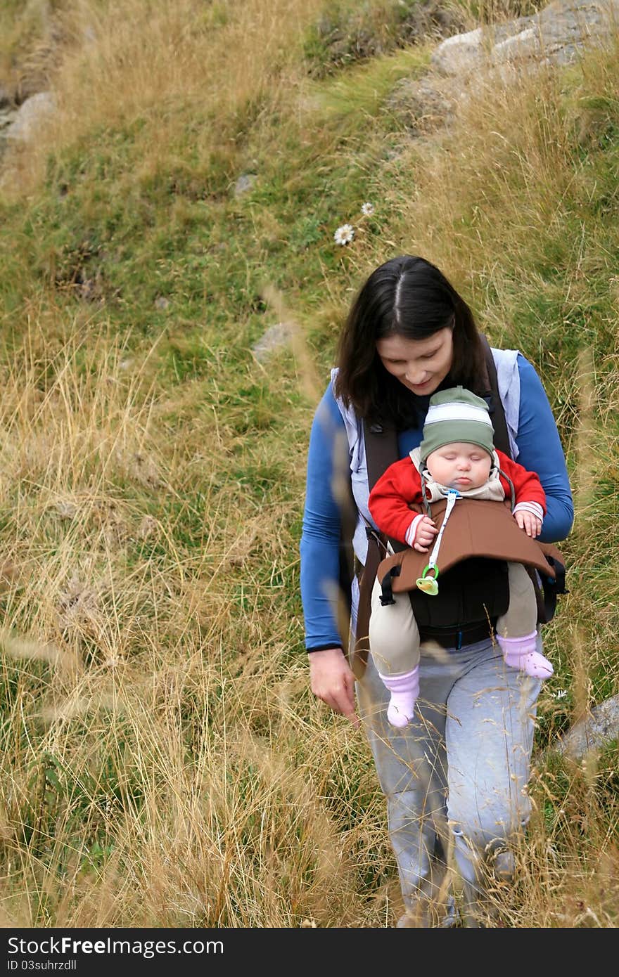 Active mother caring her newborn baby at mountain. Active mother caring her newborn baby at mountain.