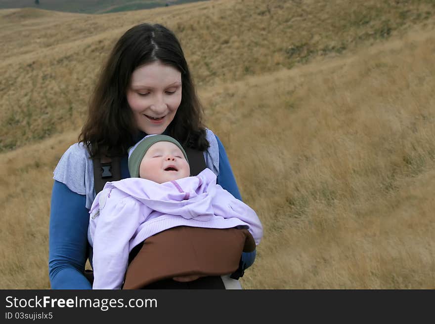 Active mother caring her newborn baby at mountain. Active mother caring her newborn baby at mountain.