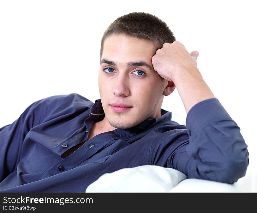 Portrait of young beautiful man lying on the sofa