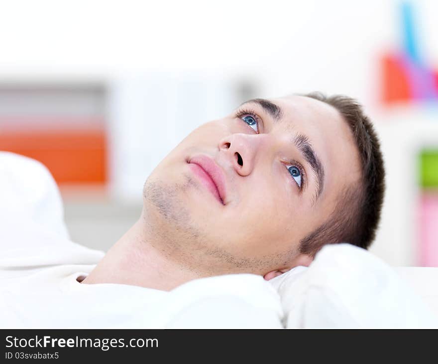 Portrait of young handsome man lying on the sofa