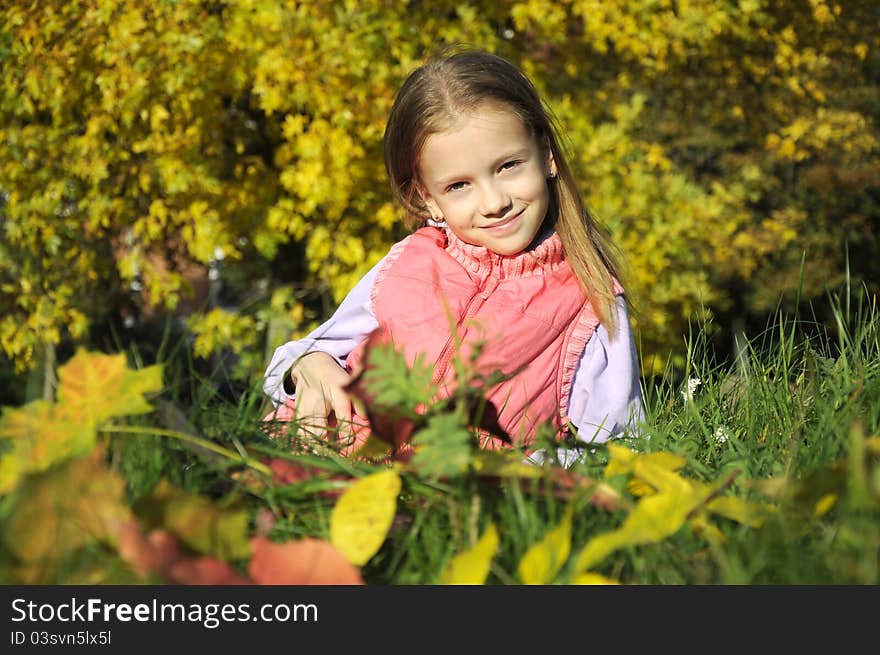 girl sitting on green grass in autumn park. girl sitting on green grass in autumn park