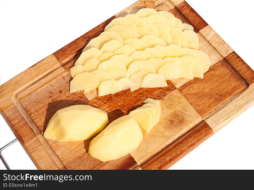 The potato sliced ​​on a cutting board at the white background. The potato sliced ​​on a cutting board at the white background