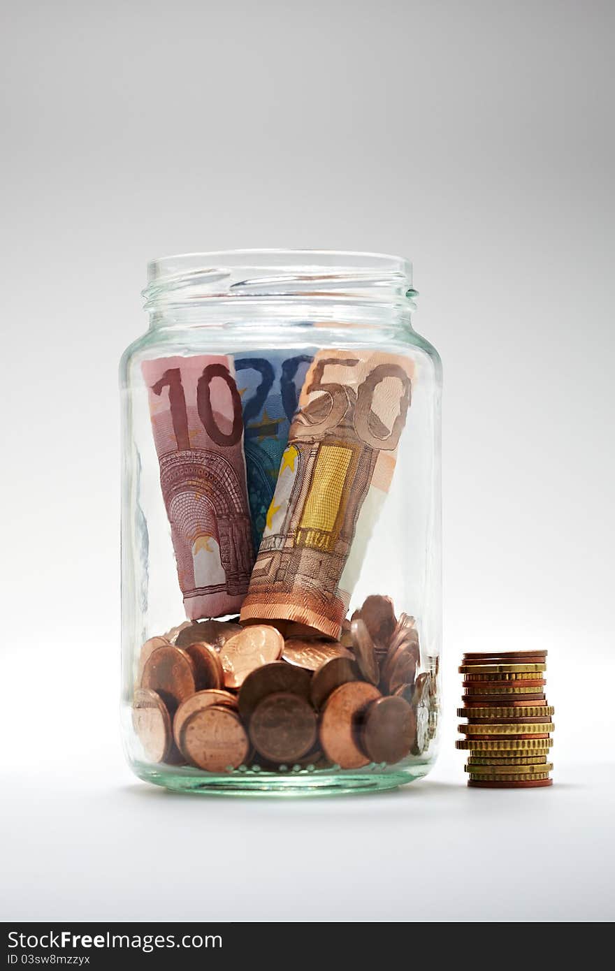 Euro coins and notes in a glass jar. Euro coins and notes in a glass jar