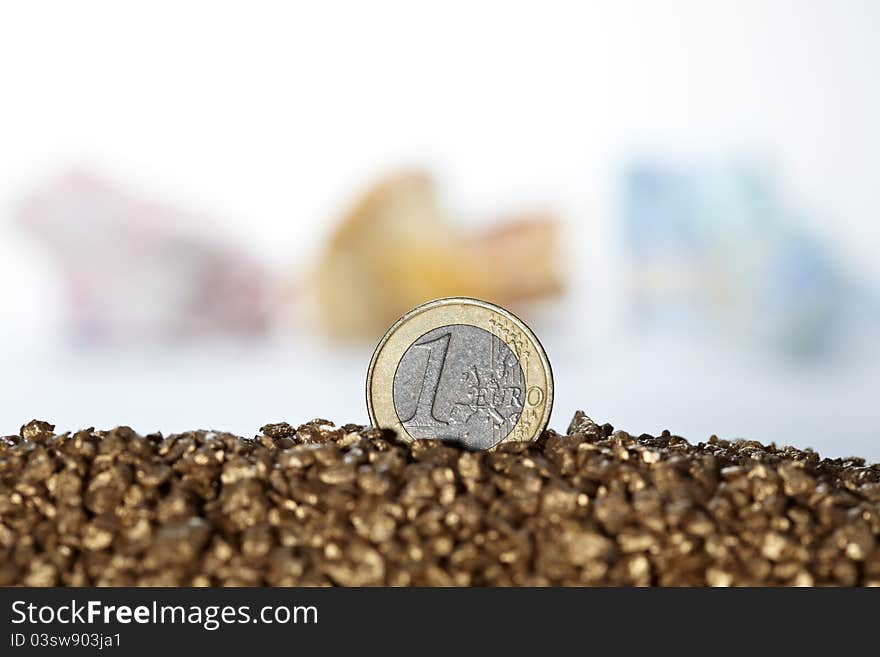 One euro coin standing alone in gold with background of other bank notes. One euro coin standing alone in gold with background of other bank notes