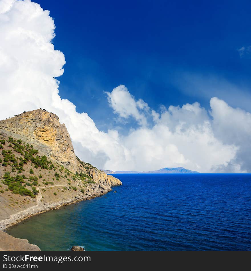 Beautiful landscape with mountain and sea. White clouds in blue sky. Best place for travel, vacation and alpinism.