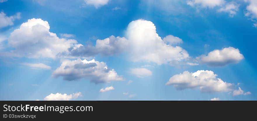 Peaceful background - beatiful blue sky, white clouds, sun beams, light from above