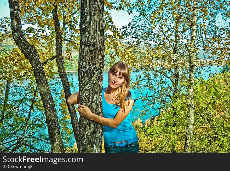 Girl in a suburban park in a forest and river. autumn. Girl in a suburban park in a forest and river. autumn