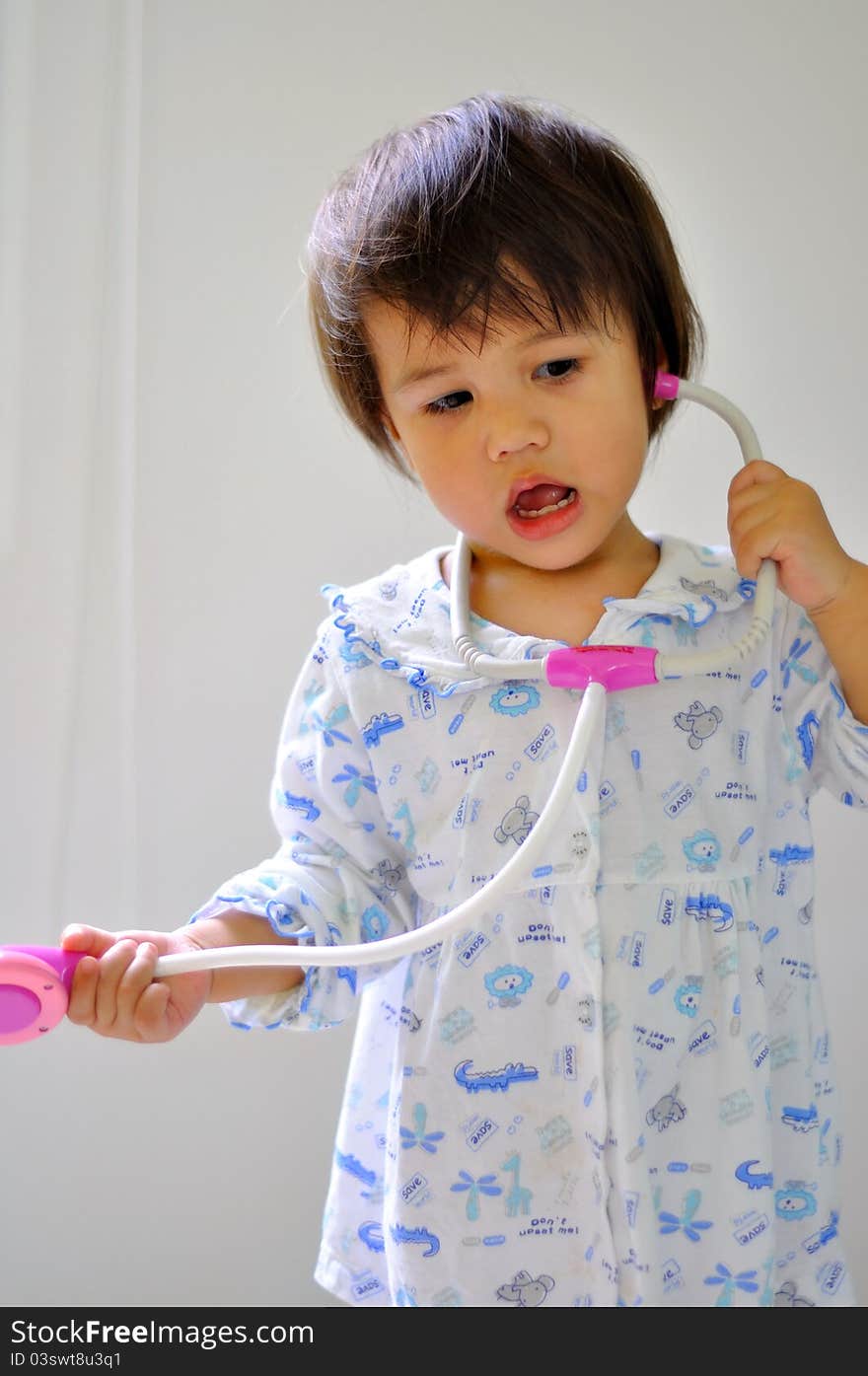 Portrait cute kid with stethoscope toy on a white background.