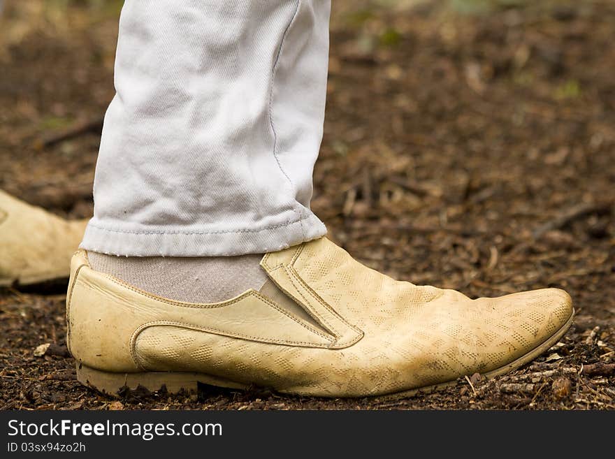 Human feet leather boots standing on the forest floor