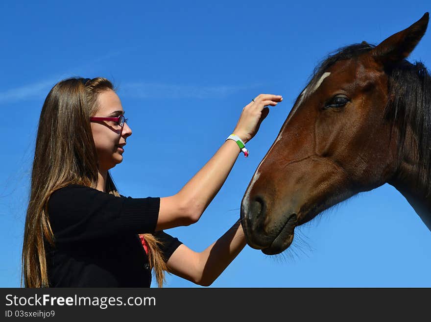 Girl caressing horse