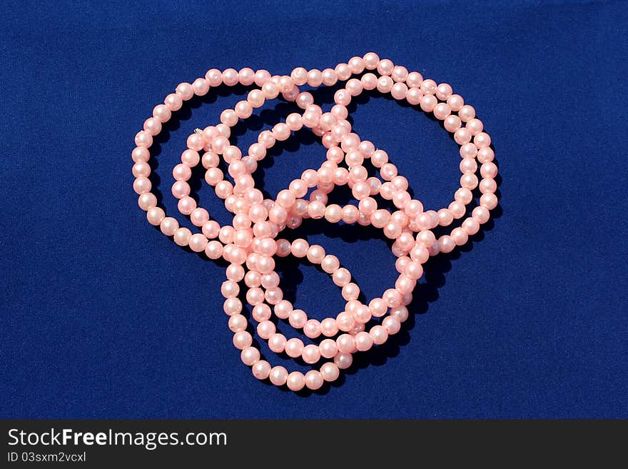 Beautiful pink pearl chains on blue background