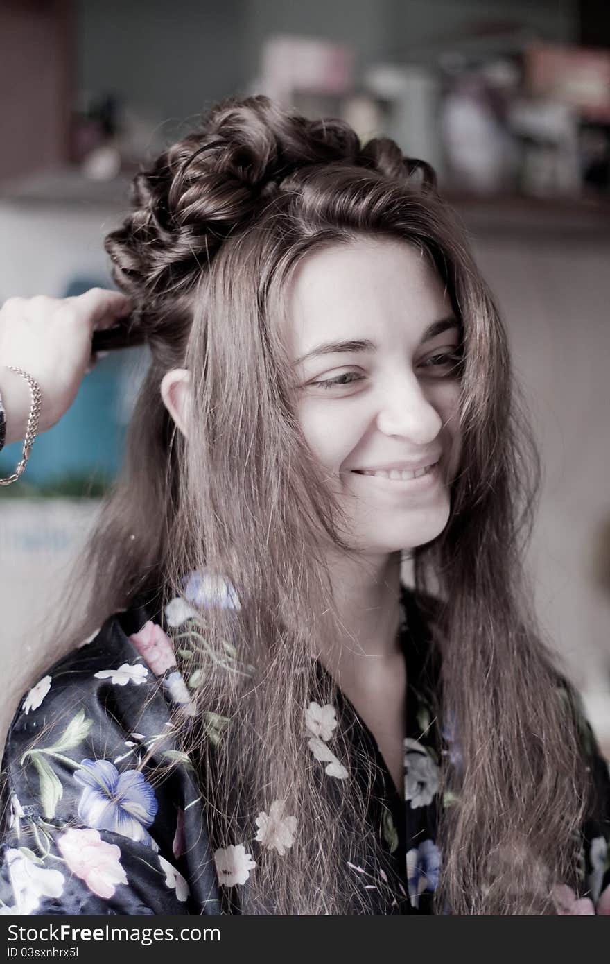 Hands of the hairdresser doing hair to the bride